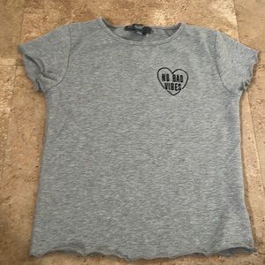 Wha I am selling is a grey top for kids with a heart saying “NO BAD VIBES”